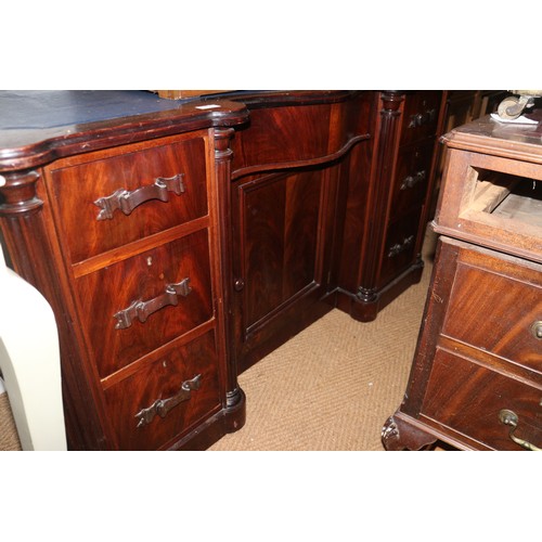 650 - A mahogany serpentine front desk with tooled lined top, fitted seven drawers with ribbon handles and... 