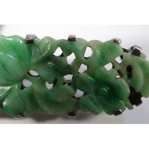 346 - A Chinese floral carved green jade and white metal mounted brooch and a similar bracelet