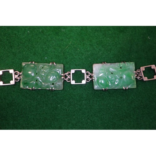 346 - A Chinese floral carved green jade and white metal mounted brooch and a similar bracelet