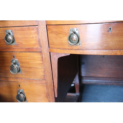 654 - An Arts & Crafts walnut break bowfront double pedestal desk with tooled lined top, fitted seven draw... 