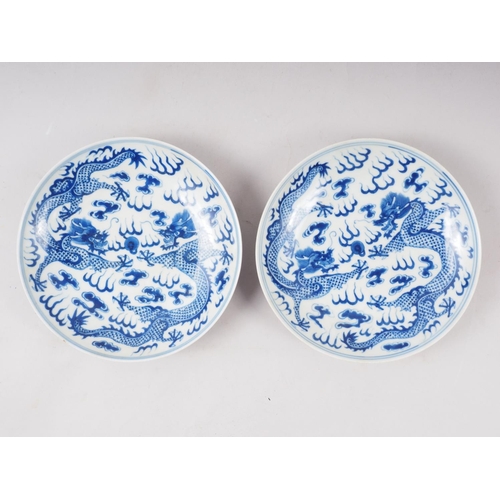 134 - A pair of Chinese porcelain blue and white dishes, decorated dragons, clouds, and flaming pearls, ba... 