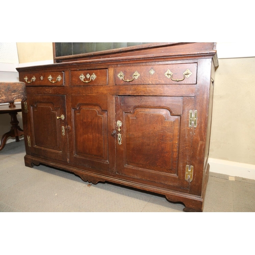 566 - A George III oak dresser, fitted shelves over three drawers and two cupboards enclosed arched panel ... 