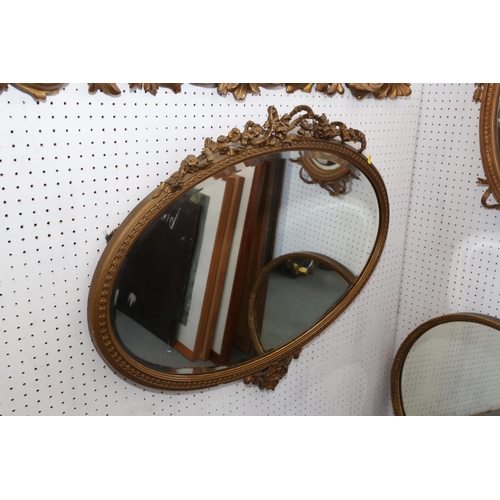 618 - An oval gilt framed wall mirror with ribbon crest plate, 17