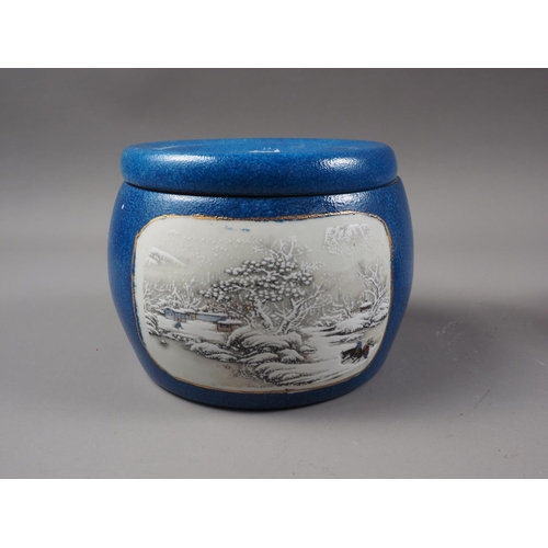 146 - A Chinese drum-shaped pot and cover with two panels decorated figures in landscapes on a blue glaze ... 