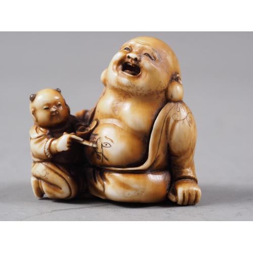 162 - A Japanese carved ivory netsuke Hotei with acolyte painting on his stomach, signed, 1 1/4