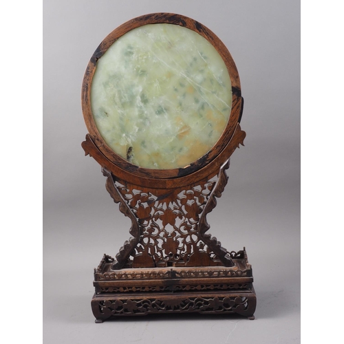 168 - A Chinese circular jade and hardstone inlaid table screen, on carved and pierced stand, 21 1/2