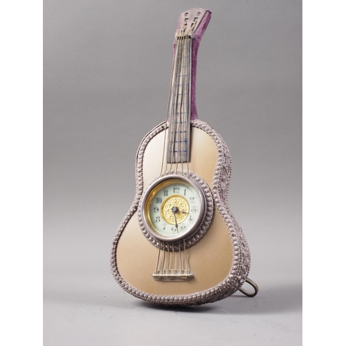 181 - An easel clock, formed as an acoustic guitar with cream enamel dial and Arabic numerals