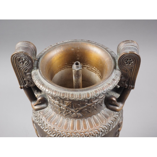 194 - An anodised brass urn with relief Greek classical decoration, on turned wooden base, 14 1/4