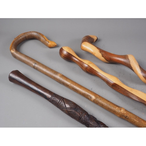 221 - A twisted hardwood walking stick, a similar walking stick, another walking stick with carved figure ... 