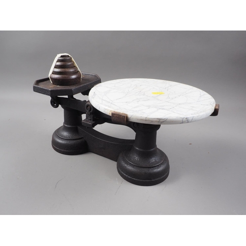 266 - A cast iron cheese balance with marble effect top and weights