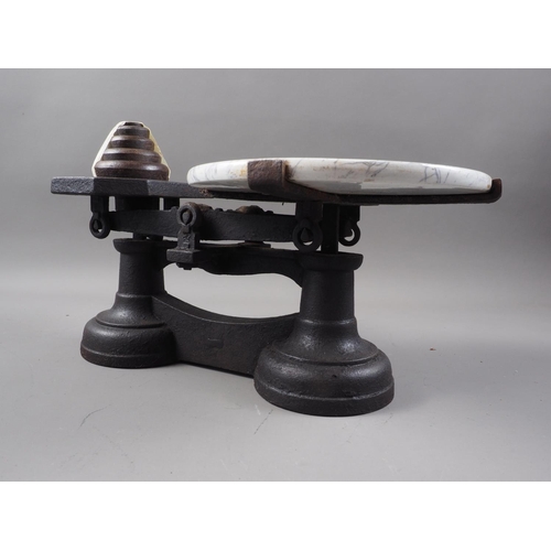 266 - A cast iron cheese balance with marble effect top and weights