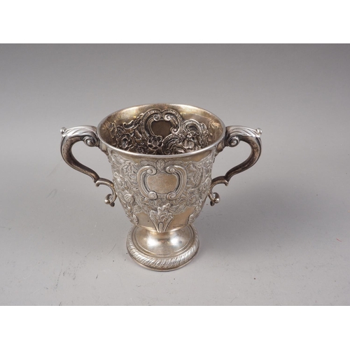 387 - A Georgian silver two-handled pedestal cup with later embossed decoration, 13.8oz troy approx