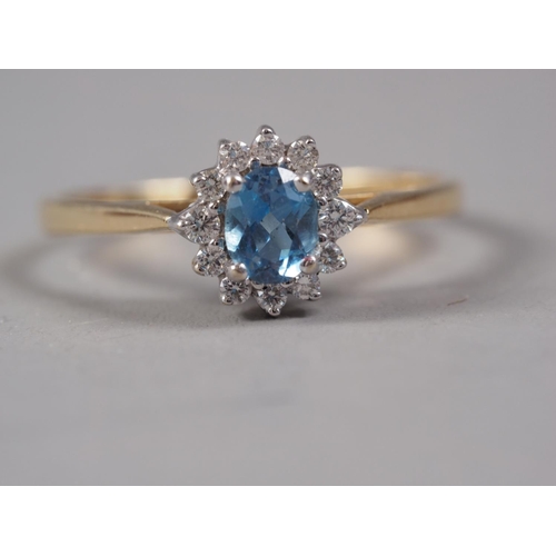 402 - An 18ct gold aquamarine and diamond cluster ring, size P