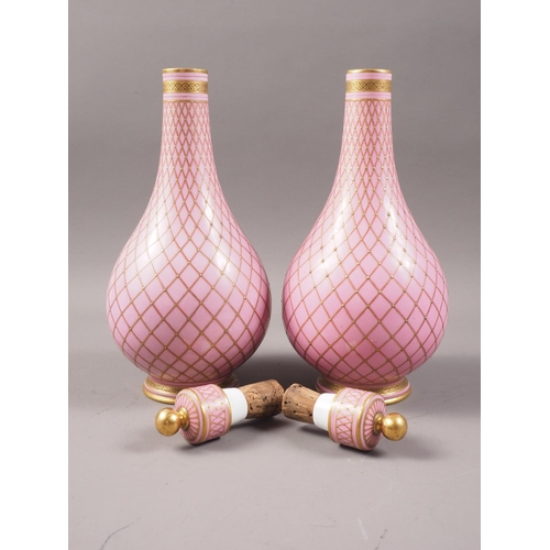 41 - A pair of Sevres style porcelain bottle vases and covers with all-over lattice decoration on a pink ... 