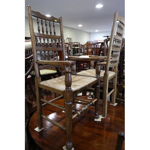 717 - A set of six oak spindle back dining chairs with rush envelope seats, on turned and stretchered supp... 