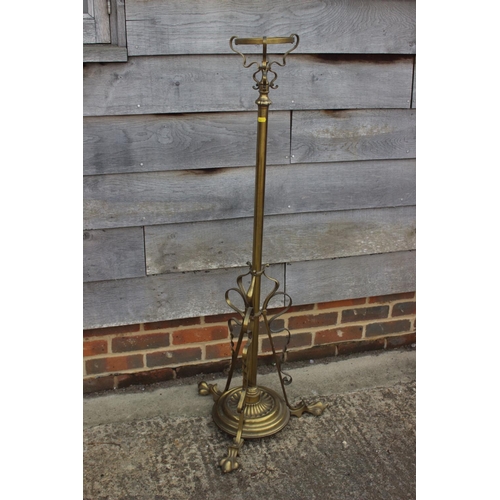 322 - An early 20th century brass scrollwork standard lamp with reservoir and etched glass shade