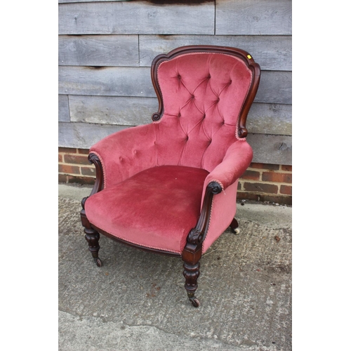 584 - A Victorian mahogany showframe armchair, button upholstered in a pink Dralon, on turned supports