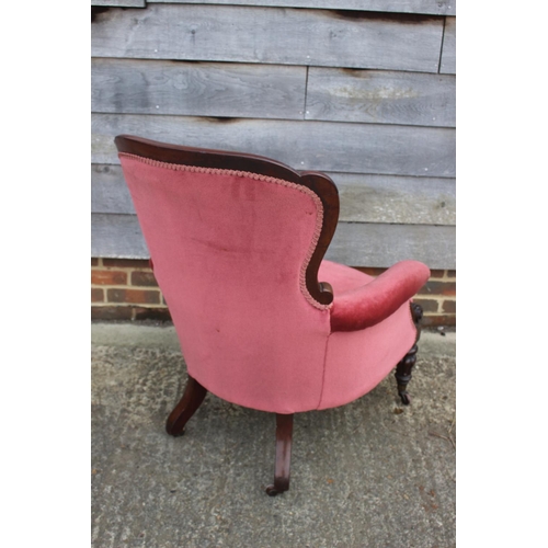 584 - A Victorian mahogany showframe armchair, button upholstered in a pink Dralon, on turned supports