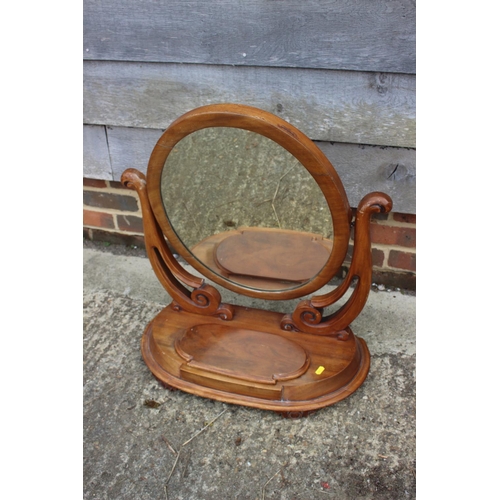 624 - An oval swing frame toilet mirror with plateau base, fitted jewel compartment, 24