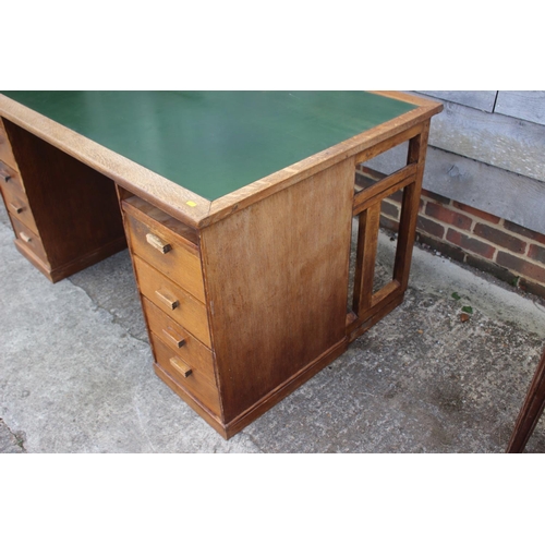 640 - A 1920s oak desk, fitted eight drawers and green leatherette top, 58