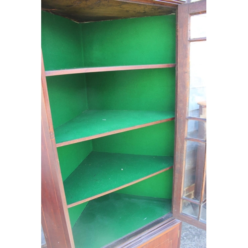 691 - A mahogany two-section corner display cabinet, the upper section enclosed astragal glazed door over ... 