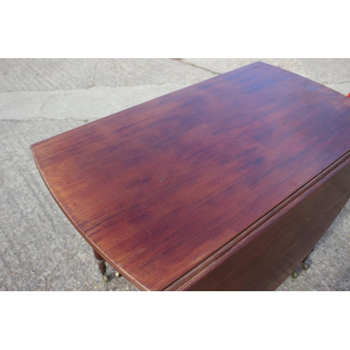 692 - A mahogany oval drop leaf dining table, on turned and castored supports, 38