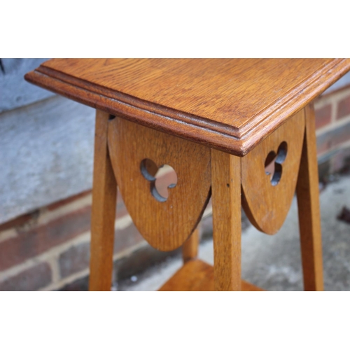 704 - A light oak two-tier occasional table with pierced trefoil design, on square supports, 11