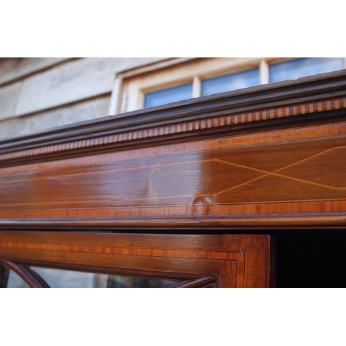 705 - An Edwardian walnut banded and line inlaid display cabinet with astragal glazed doors enclosed two s... 