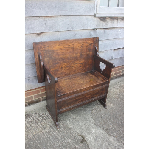 711 - A Monk's dark oak bench with hinged panel seat, 36