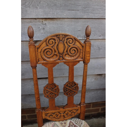 712 - A set of four carved light oak high backed dining chairs with upholstered floral pattern seats