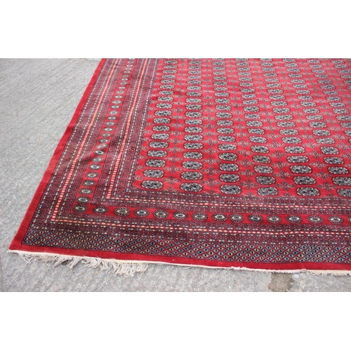 748 - A Bokhara carpet of traditional design with numerous octagonal guls on a red ground, 111