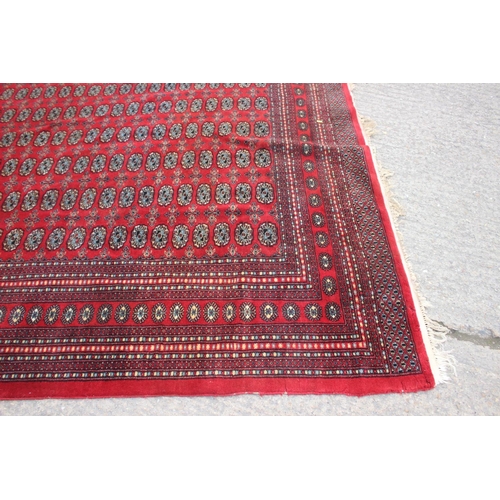 748 - A Bokhara carpet of traditional design with numerous octagonal guls on a red ground, 111