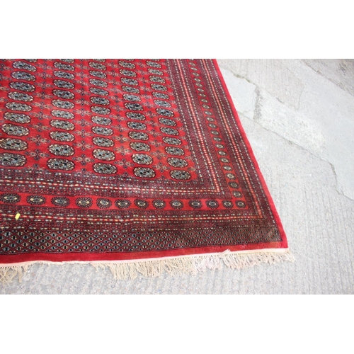 748 - A Bokhara carpet of traditional design with numerous octagonal guls on a red ground, 111