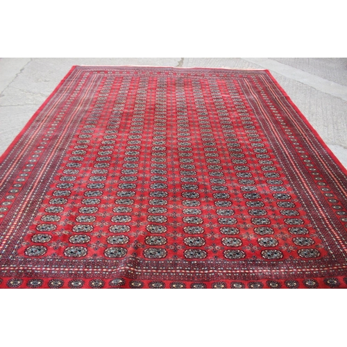 748 - A Bokhara carpet of traditional design with numerous octagonal guls on a red ground, 111