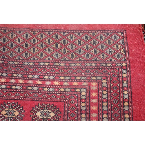 748 - A Bokhara carpet of traditional design with numerous octagonal guls on a red ground, 111