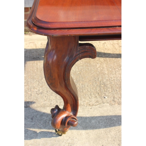 609 - A Victorian carved mahogany extending dining table with two extra leaves, on cabriole scroll support... 