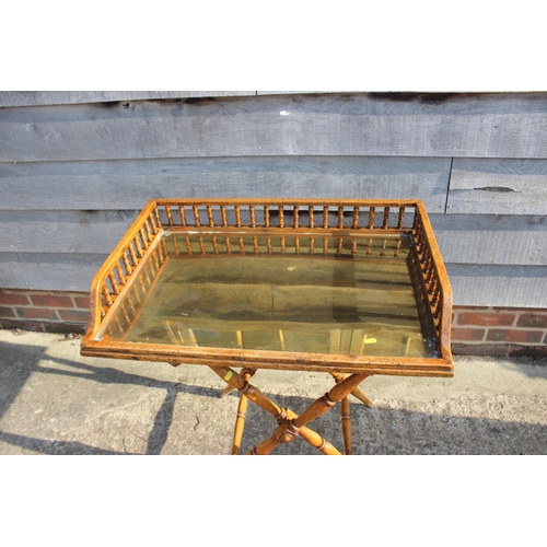 672 - A butler's satin birch spindle galleried tray with brass base, on 'X' frame stand, 30