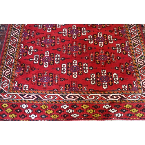 729 - A Caucasian rug with shaped guls, on a red ground and multi-geometric borders, 75