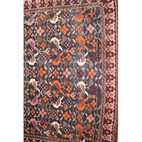 730 - A Caucasian rug with all-over bird design on dark blue ground in shades of orange, blue, pink, red a... 