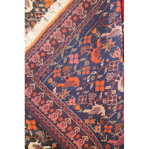 730 - A Caucasian rug with all-over bird design on dark blue ground in shades of orange, blue, pink, red a... 