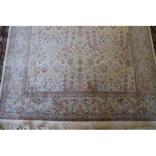 734 - A Qum silk rug with all-over garden design in shades of cream, blue, green and red, signed, 72