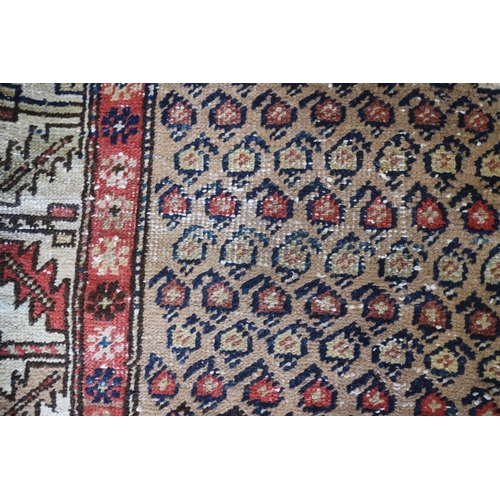 737 - A tribal runner with all-over boteh design on a camel ground and two geometric borders, in shades of... 