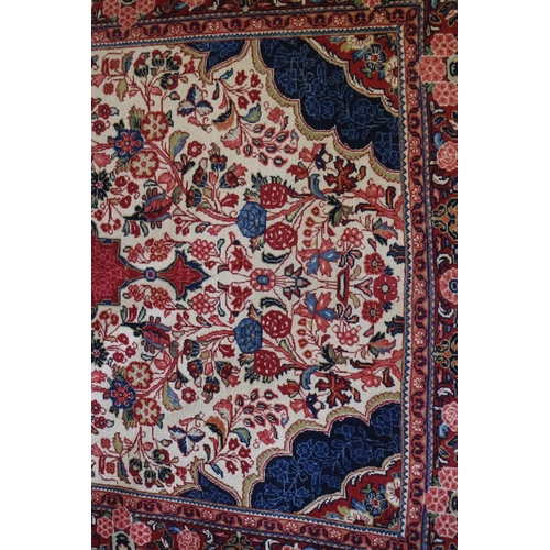 739 - A Kashan rug with red central medallion on a floral scroll and cream ground with triple floral borde... 