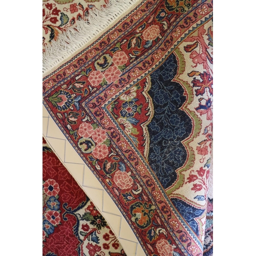 739 - A Kashan rug with red central medallion on a floral scroll and cream ground with triple floral borde... 