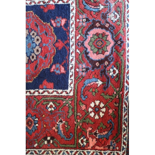 742 - A Tabriz runner with seven octagonal guls and six white rosettes on a blue ground with floral border... 