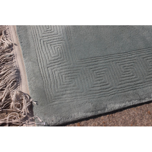 747 - A Chinese rug with geometric border on a pale green ground, 72