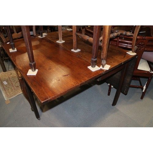 547 - A Georgian oak drop leaf dining table, on moulded chamfered supports with brass castors, 40