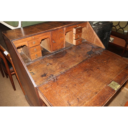 573 - A late Georgian provincial oak fall front bureau with fitted interior drawers, pigeonholes and centr... 