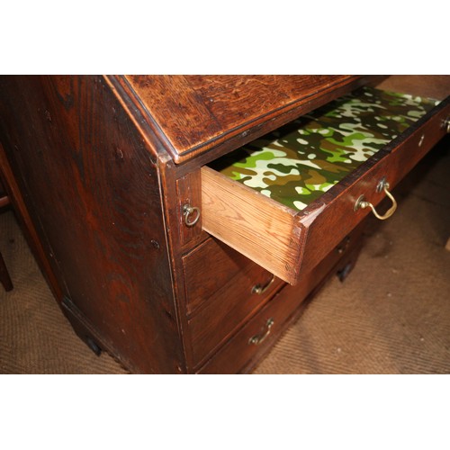 573 - A late Georgian provincial oak fall front bureau with fitted interior drawers, pigeonholes and centr... 