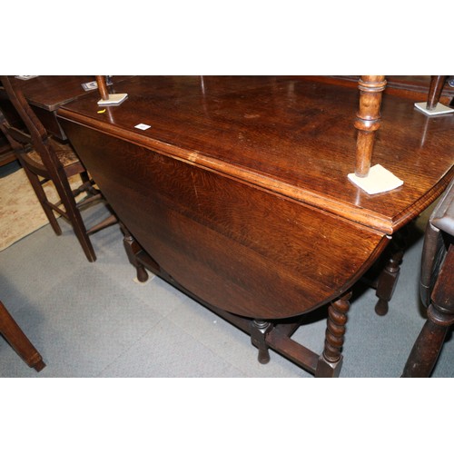 605 - An oak oval top drop leaf dining table, on barley twist stretchered supports, 40